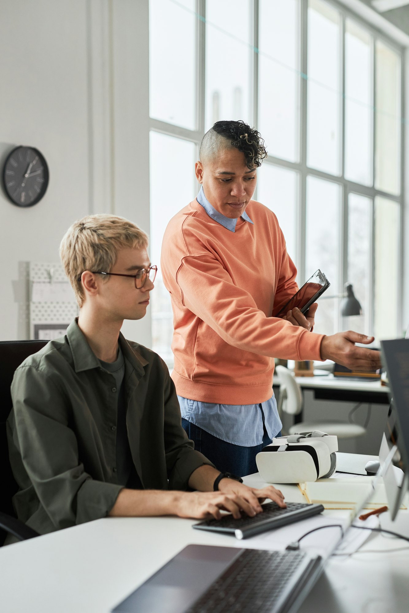 Colleagues discussing online presentation on computer